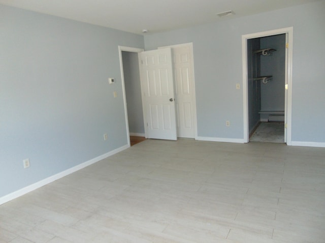 unfurnished bedroom featuring a walk in closet and a closet