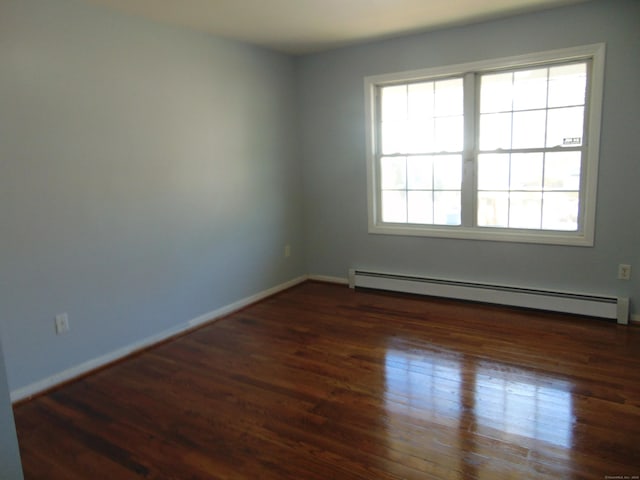 spare room featuring dark hardwood / wood-style flooring and a baseboard radiator