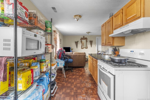 kitchen featuring a textured ceiling, dark parquet flooring, and white appliances