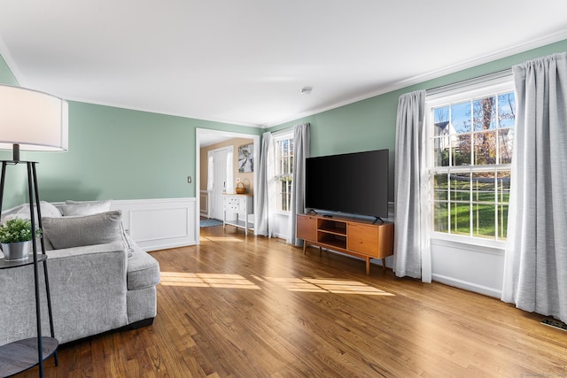 living room featuring wood-type flooring and ornamental molding