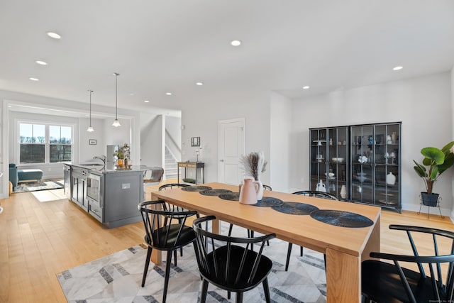 dining space with light wood-type flooring and sink