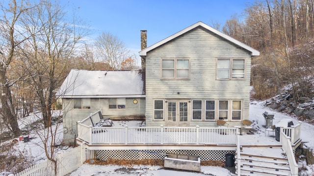 snow covered house featuring a deck