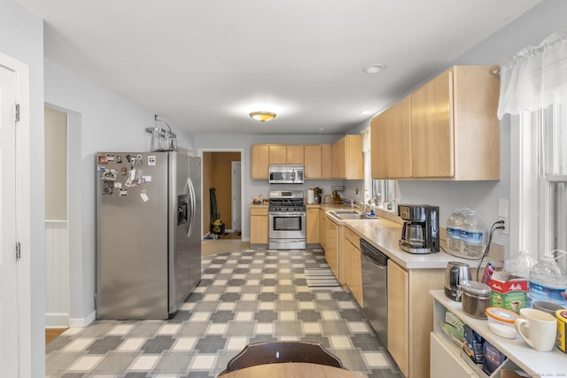 kitchen featuring light brown cabinets, stainless steel appliances, and sink