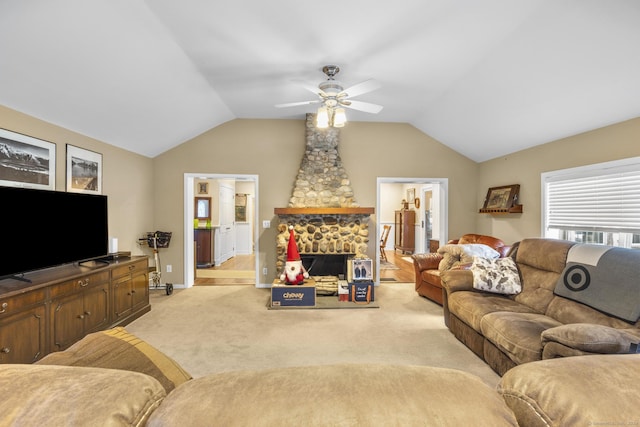 living room featuring light carpet, vaulted ceiling, ceiling fan, and a stone fireplace