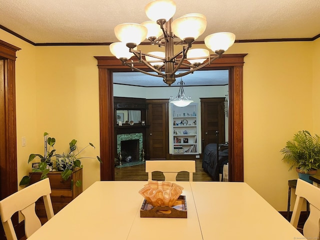 dining room featuring ornamental molding, a textured ceiling, and an inviting chandelier