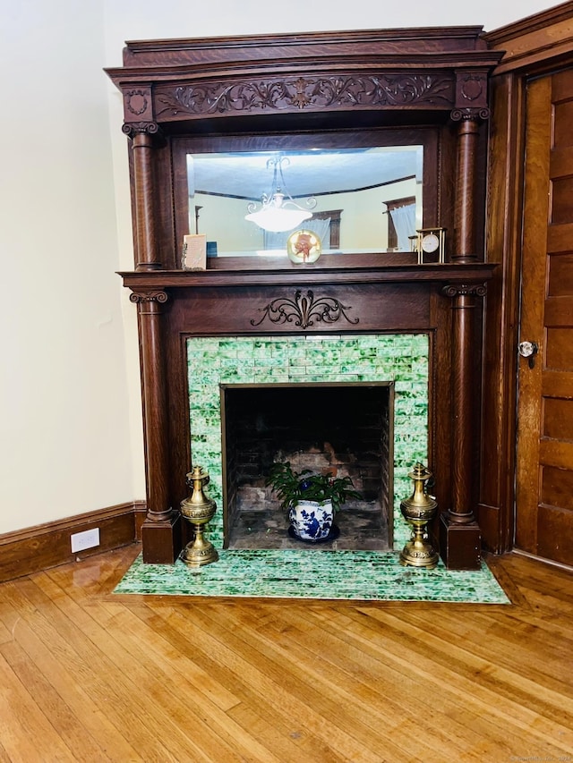 interior details with a tile fireplace and wood-type flooring