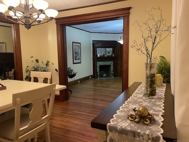 dining area featuring crown molding, dark hardwood / wood-style flooring, a chandelier, and a textured ceiling