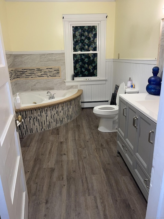 bathroom with a washtub, vanity, baseboard heating, hardwood / wood-style flooring, and toilet