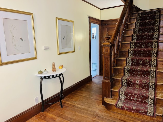 stairs featuring hardwood / wood-style floors and crown molding