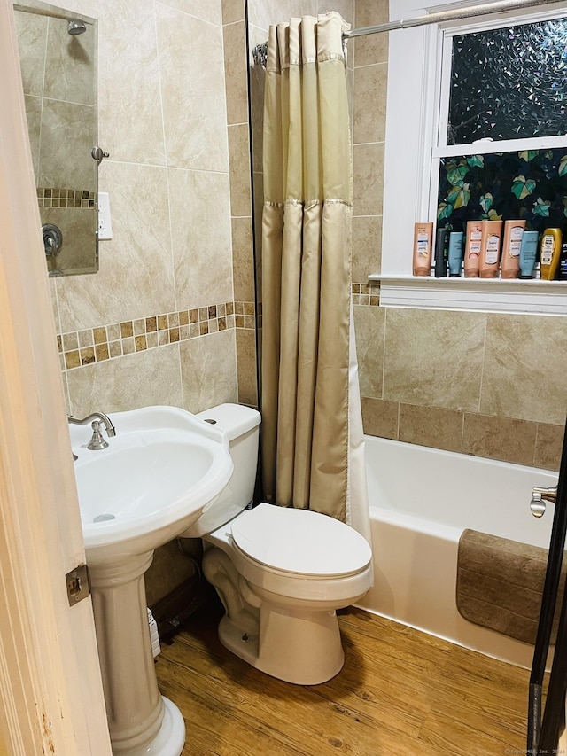 bathroom featuring shower / tub combo, hardwood / wood-style flooring, toilet, and tile walls