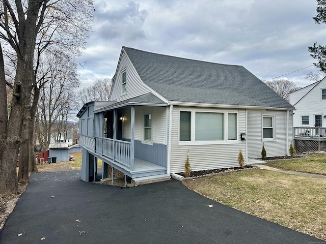 view of front of house with covered porch and a front lawn