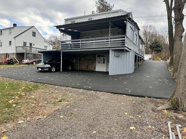 rear view of house featuring a balcony and a carport