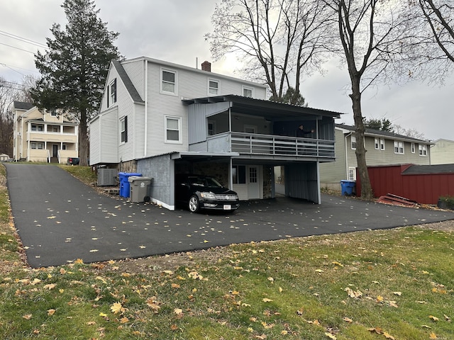 back of house featuring a carport and cooling unit