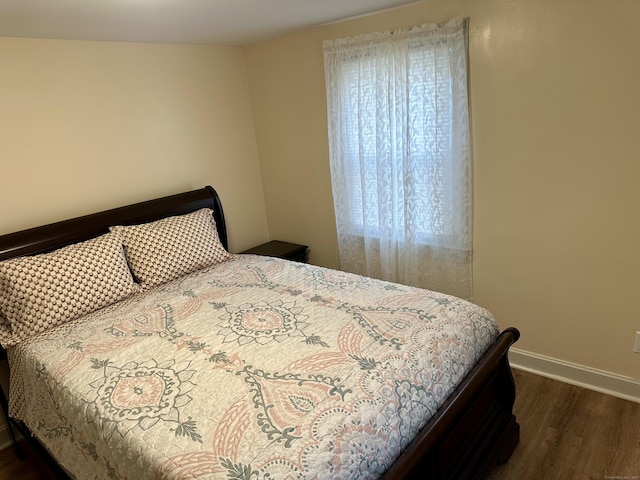 bedroom with dark wood-type flooring