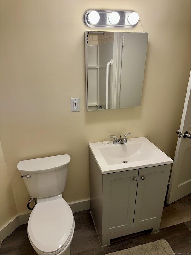 bathroom with hardwood / wood-style floors, vanity, and toilet