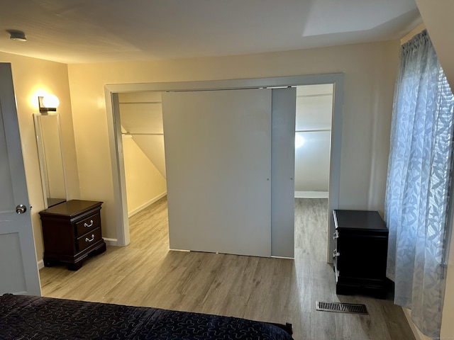 bedroom with light hardwood / wood-style flooring and a closet