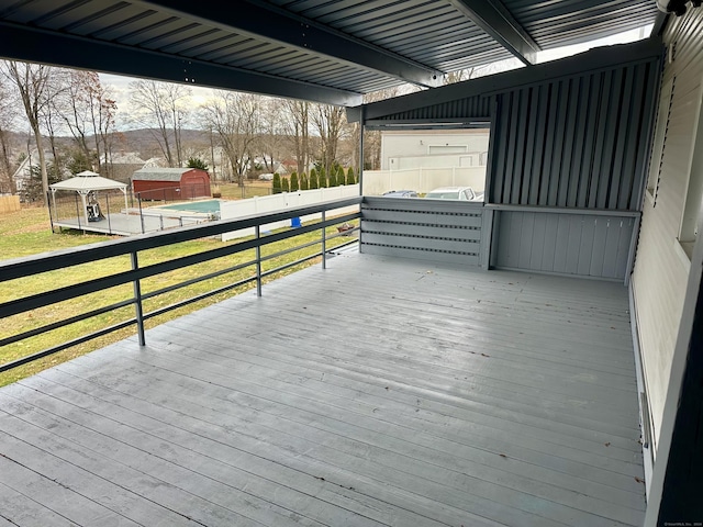 wooden deck with a lawn and a storage shed