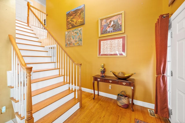 staircase with hardwood / wood-style floors and a healthy amount of sunlight