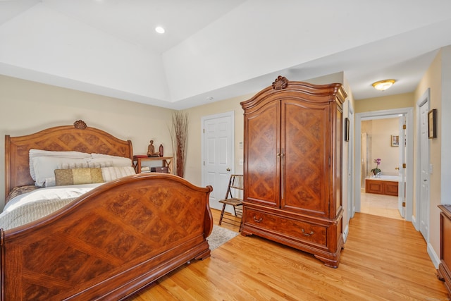 bedroom featuring ensuite bathroom and light wood-type flooring