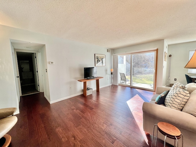 living room featuring dark hardwood / wood-style flooring and a textured ceiling