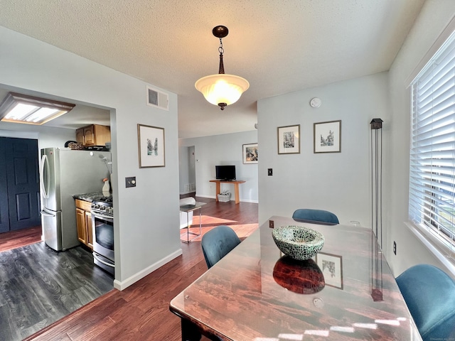 dining area featuring a textured ceiling and dark wood-type flooring