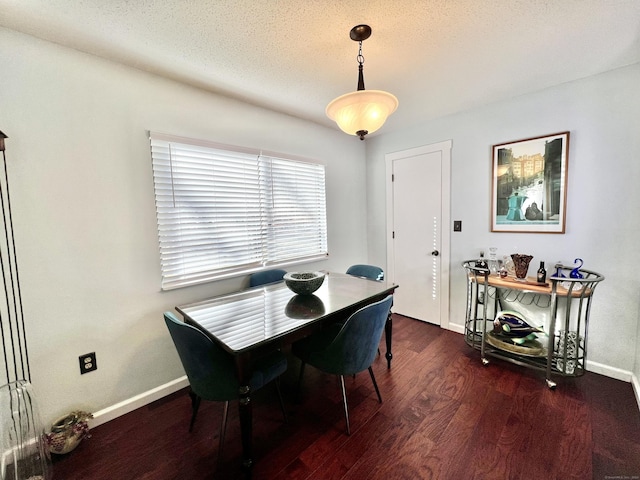 dining room with dark hardwood / wood-style floors and a textured ceiling