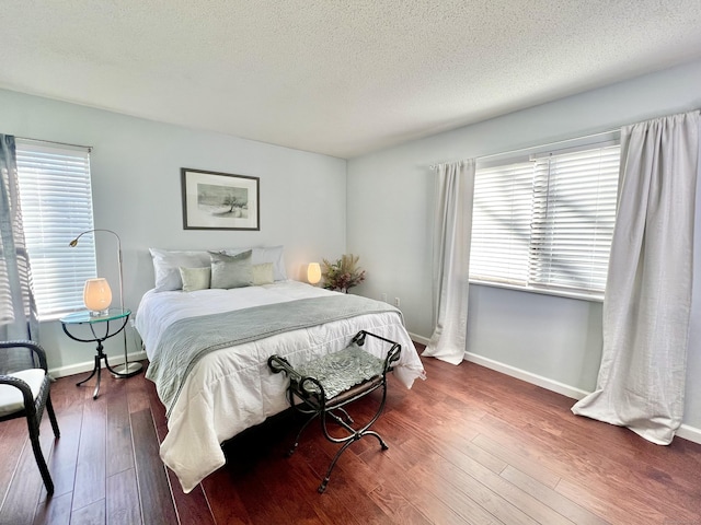 bedroom featuring dark hardwood / wood-style flooring and a textured ceiling