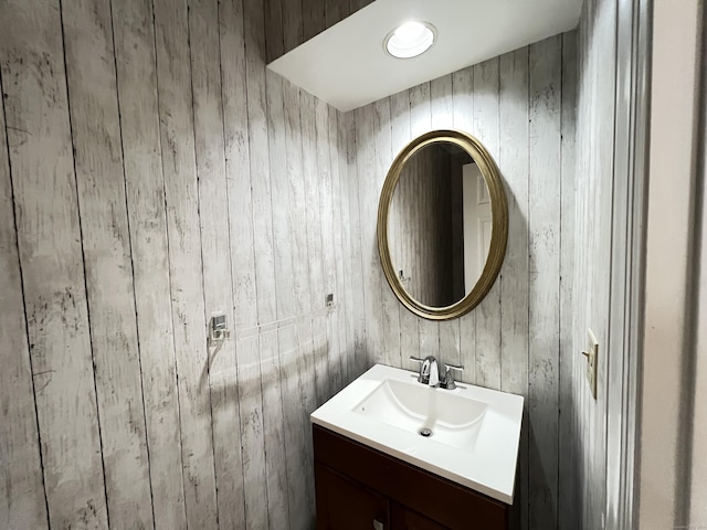 bathroom featuring vanity and wooden walls