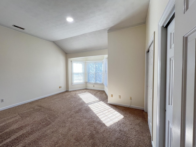 unfurnished bedroom with carpet and lofted ceiling