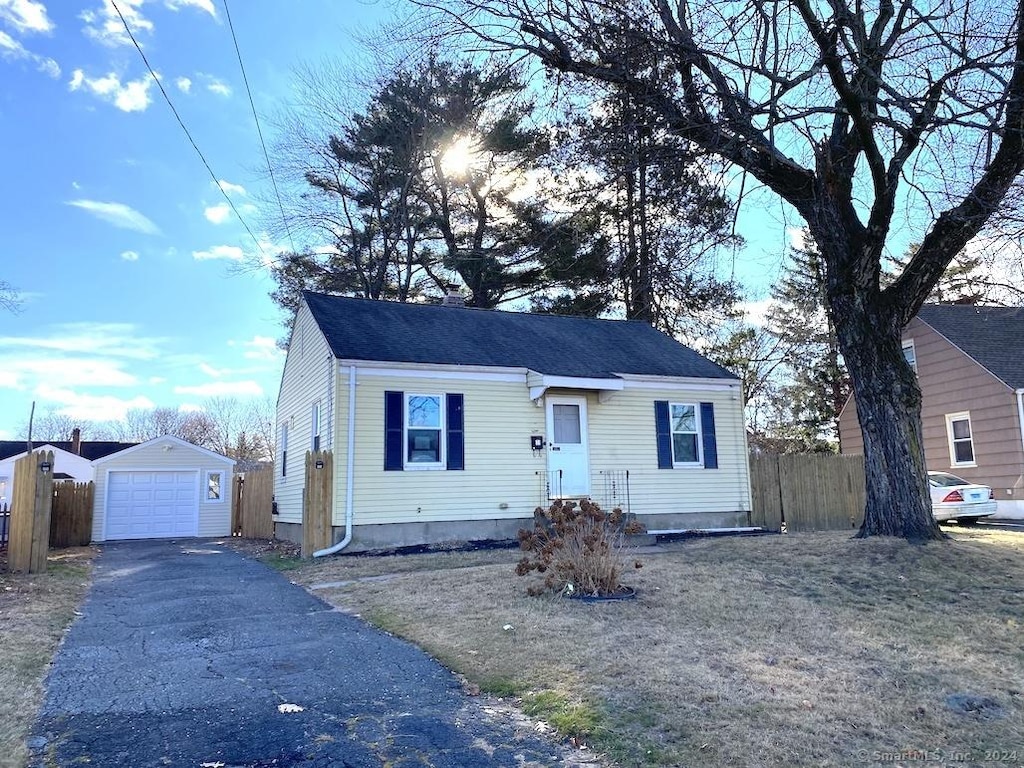 view of front facade with a front yard, a garage, and an outdoor structure