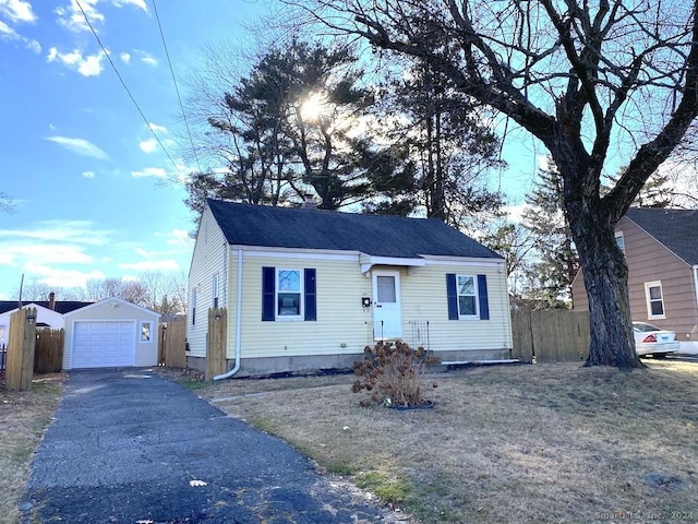 view of front facade with a front yard, a garage, and an outdoor structure