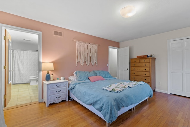 bedroom featuring ensuite bathroom and light hardwood / wood-style floors