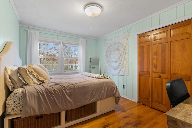 bedroom featuring light wood-type flooring, a closet, and ornamental molding