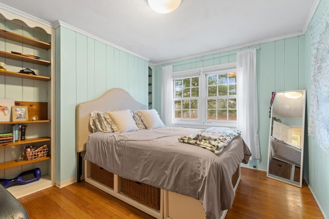 bedroom with wood-type flooring and ornamental molding