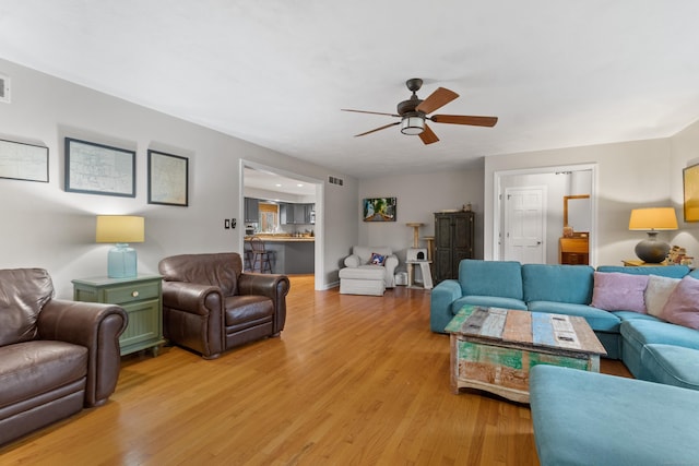 living room featuring ceiling fan and light hardwood / wood-style floors