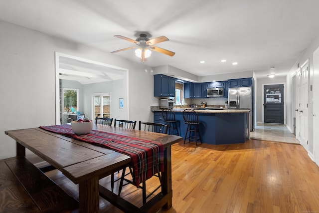 dining space with light hardwood / wood-style floors and ceiling fan