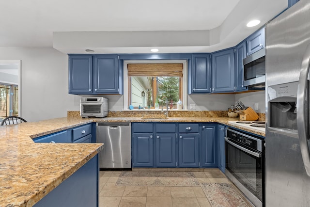 kitchen featuring sink, light tile patterned floors, blue cabinetry, and appliances with stainless steel finishes