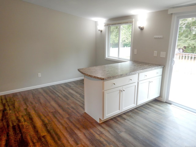 kitchen with dark hardwood / wood-style flooring, white cabinets, and a healthy amount of sunlight