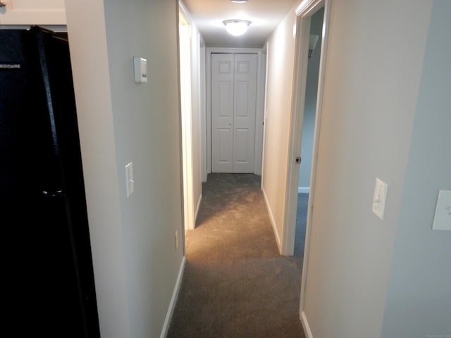 hallway featuring dark carpet