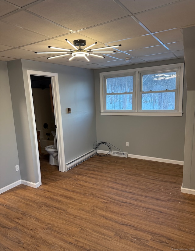 unfurnished bedroom with ensuite bathroom, dark wood-type flooring, a drop ceiling, and ceiling fan