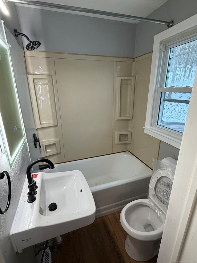 full bathroom featuring hardwood / wood-style floors, sink, toilet, and shower / bath combination