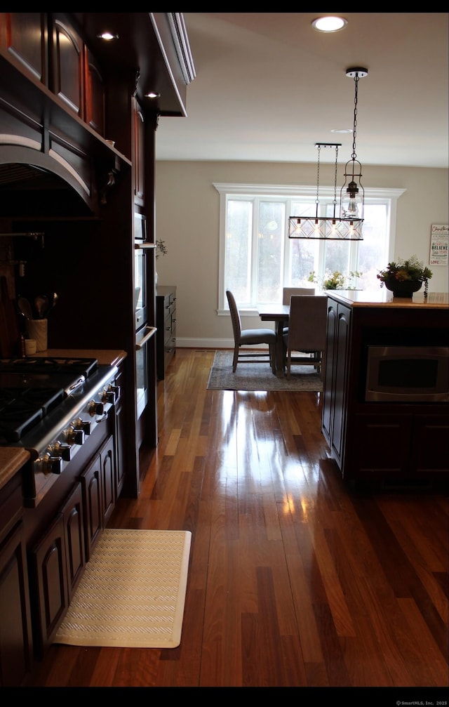 kitchen with a wealth of natural light, gas cooktop, dark hardwood / wood-style flooring, and decorative light fixtures