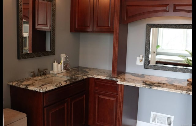 kitchen featuring sink, light stone counters, and kitchen peninsula