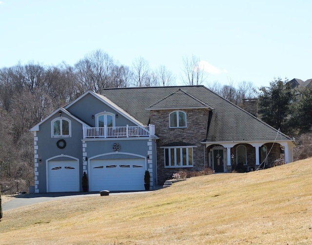 1461 Bunker Hill Rd, Watertown, CT 06795 - view of front facade featuring driveway, a balcony, stone siding, a front yard, and a garage
