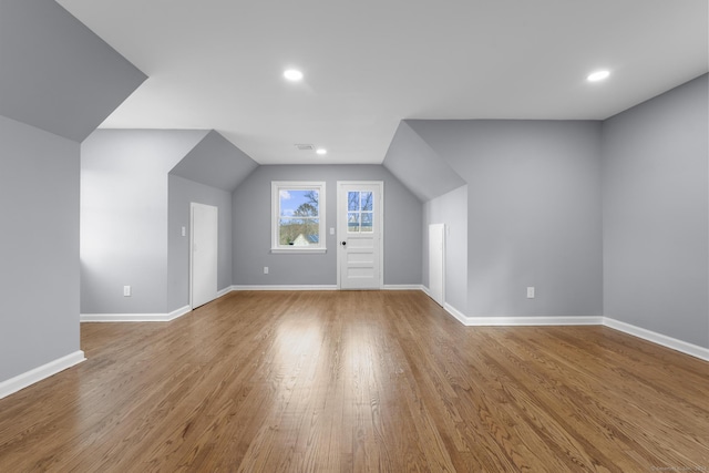 additional living space featuring light wood-type flooring and lofted ceiling