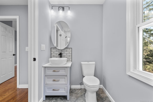 bathroom featuring plenty of natural light, vanity, wood-type flooring, and toilet