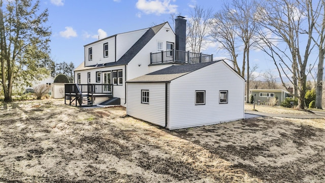 rear view of house with a balcony and a storage unit