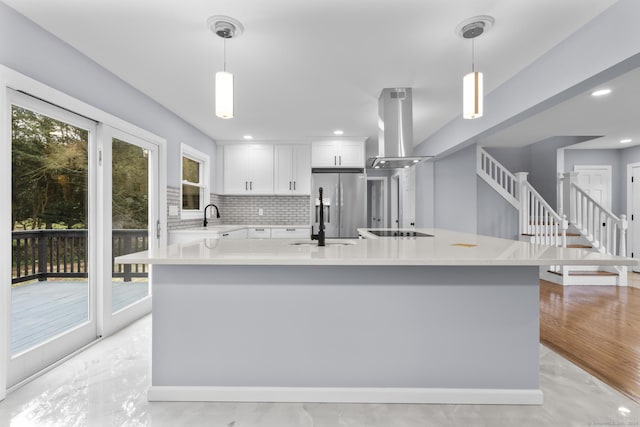 kitchen featuring island exhaust hood, stainless steel refrigerator with ice dispenser, pendant lighting, white cabinets, and a kitchen island