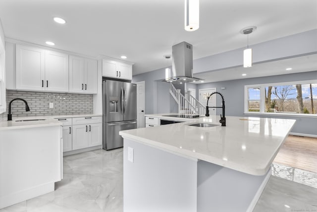 kitchen featuring stainless steel fridge with ice dispenser, a center island, decorative light fixtures, and sink