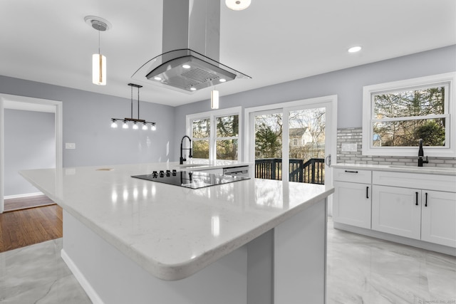 kitchen featuring island range hood, a center island, and decorative light fixtures